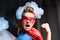 Boy in red superhero costume with fighting gesture screaming