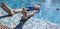 A Boy Relaxes by the Pool Outdoors. High Angle View of a Young Man in Swimming Goggles Sunbathing in the Pool