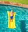 Boy Relaxing and Having Fun in Swimming Pool on Yellow Raft