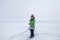 Boy removing snow from the ice on frozen lake, winter, silence and wild nature, lifestyle