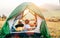 Boy rest in camping tent and enjoy with sunset light in mountain valley