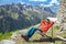 The boy is resting in a deck chair in the summer mountains