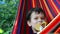 boy resting in a hammock in nature, drinking a cocktail with lemon. teenager Relaxing In Hammock. vacation concept