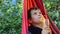 boy resting in a hammock in nature, drinking a cocktail with lemon. teenager Relaxing In Hammock. vacation concept