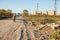 A boy rides a balance bike Garbage dump near residential buildings