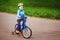 Boy rides bike along the city path in the park. small bicyclist in helmet riding bicycle.