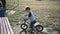 The boy rides on a runbike in the park in summer sunny weather having a good mood