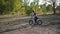 The boy rides on a runbike in the park in summer sunny weather having a good mood