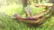 A boy rocks lying in the hammock and reads a book