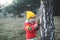 A boy in rubber boots walks through the forest and holds a magnifying glass in her hands, examines the stones, a mineral.