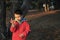 A boy in rubber boots walks through the forest and holds a magnifying glass in her hands, examines the stones, a mineral.