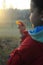 A boy in rubber boots walks through the forest and holds a magnifying glass in her hands, examines the stones, a mineral.