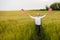 Boy runing with the american flag on the green wheat field celebrating national independence day. 4th of July concept