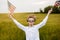 Boy runing with the american flag on the green wheat field celebrating national independence day. 4th of July concept