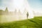 Boy running around the golf courses, which are watered with fountains