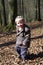 Boy running through autumn foliage