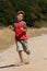 Boy running on dusty road