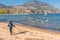 Boy running on Okanagan Beach with flying seagulls on sunny autumn afternoon