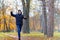 A boy running through the park and enjoys autumn, beautiful nature with yellow leaves