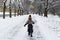 Boy runs through the park in winter. Back view. Child walks in snowy park