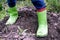 Boy`s feet in dirty rubber boots. Leisure for children in the village.The boy is standing in the ground. Close up macro