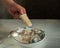 A boy`s hand taking homemade ice cream from a deep plate with other portions of ice cream.