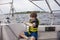 Boy sailing pulling ropes to adjust sails on sailboat