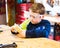 Boy sanding wooden block in workshop