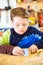 Boy sanding wooden block in workshop