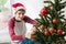 Boy with santa claus hat decorating christmas tree at home