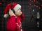 Boy in Santa Claus hat and headset is singing or talking into microphone with pop filter in voice recording studio.