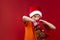 boy in a Santa hat rummages in a Christmas bag in search of gifts