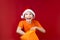 Boy in a Santa hat rummages in a yellow Christmas gift bag and laughs loudly