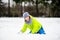 The boy of school age plays snowballs in the winter park.