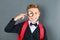 Boy in school uniform with magnifier against board