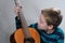 Boy schools himself to play the  acoustic guitar