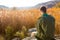 Boy Scout Sitting on the Rock Watching Brown Field