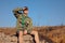 Boy Scout Sitting on Rock Watching Over the Field