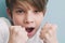 Boy screams and jokingly threatens with his fists in fighting stance