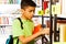 Boy searches books on library bookshelf