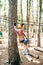 Boy on a security line goes on an agility bridge in adventure park