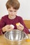 Boy separating egg white from egg yolk