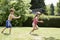 Boy Shooting Girl With Water Pistol In Backyard