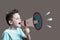 Boy shouting through vintage megaphone. Communication concept