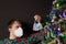 Boy showing protection mask near Christmas tree