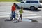 Boy and sister stand before zebra crossing