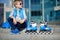 Boy siting with inline roller skates at outdoor skate park