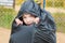 Boy sits in a big black garbage bag and looks through a hole in it, abandoned children concept