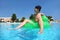 Boy sits on inflatable arm-chair in pool