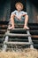 Boy sits on the ladder in hayloft